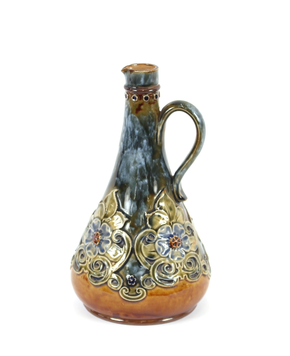 A Doulton stoneware ewer, decorated in the Art Nouveau manner, with raised floral heads, 23cm high