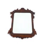 A mahogany framed wall mirror, in the Chippendale manner, having fret carved frieze and cushion