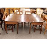 A George III mahogany D end dining table, with extra centre leaf, raised on ring turned tapering