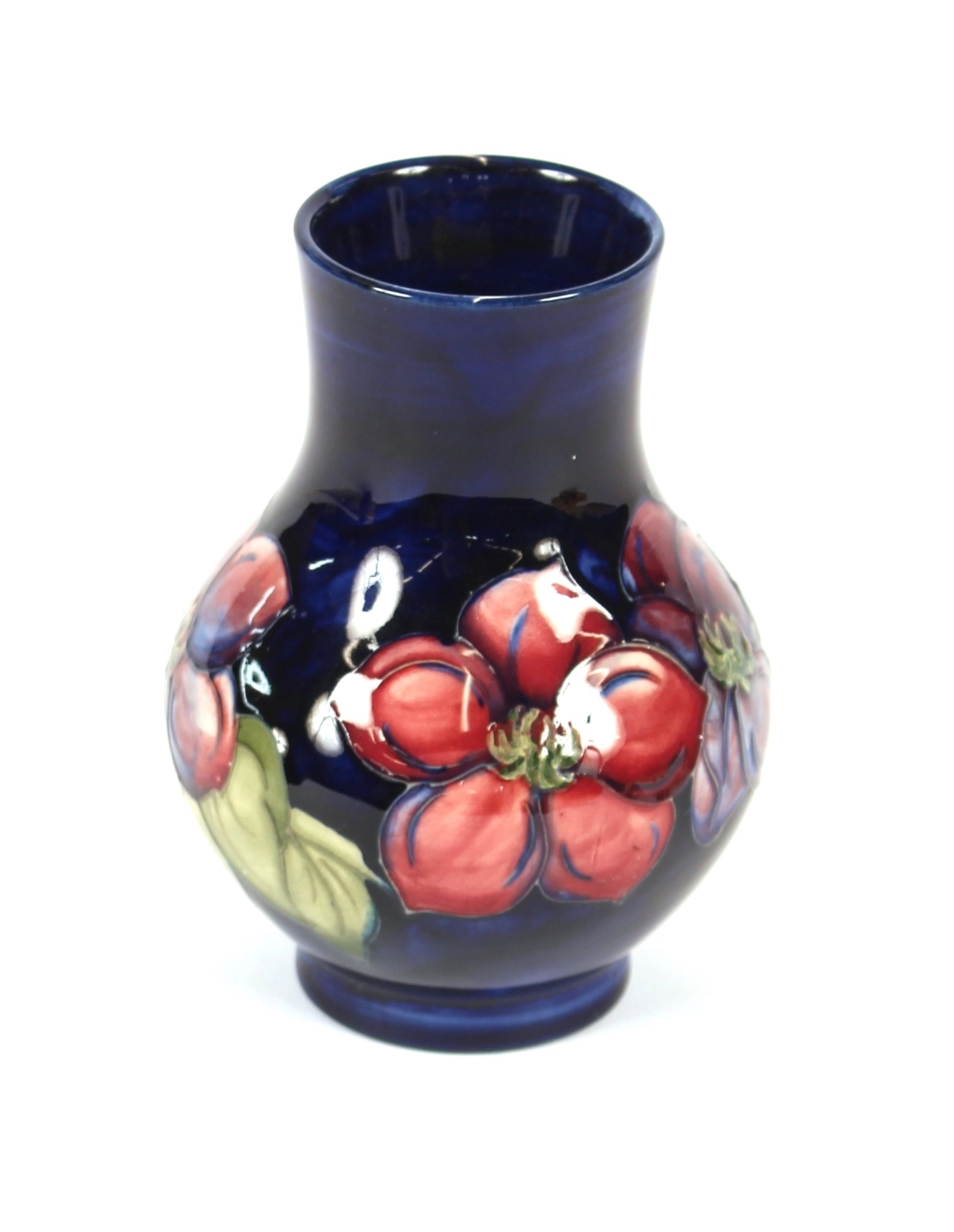 A blue Moorcroft baluster vase, decorated with pomegranates and leaves, 13cm high; and a smaller