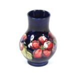 A blue Moorcroft baluster vase, decorated with pomegranates and leaves, 13cm high; and a smaller