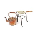 A Victorian copper kettle; and a 19th Century brass and steel trivet, with turned wooden handle, (