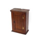 An 18th Century oak hanging spice cupboard, enclosed by a single panelled door, 50cm wide x 70cm