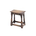 An oak joint stool, raised on turned baluster supports, united by stretchers, 46cm wide