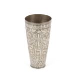 An Eastern white metal beaker, profusely decorated with foliage, 18cm high