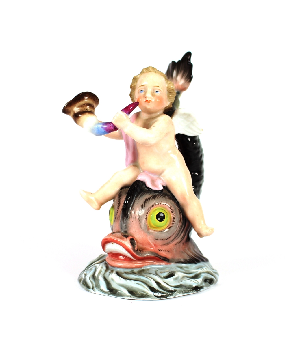 A small late 19th Century German porcelain figure, depicting a cherub riding on a stylised dolphin's