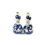 A pair of oriental double gourd shaped blue and white porcelain vases, decorated with symbols,