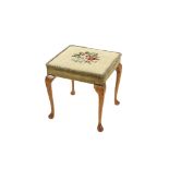 A walnut dressing stool, raised on cabriole supports with floral needlepoint upholstery