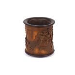 A Chinese carved bamboo brush pot, deeply carved with seated figures amongst foliage and bamboo,
