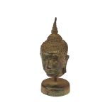 Two oriental bronze Buddha heads, 17cm high