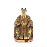 An Antique carved wooden Chinese figure of a seated immortal, with painted and gilded decoration,