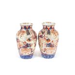 A pair of 19th Century Japanese Imari baluster vases, having raised decoration of dragon's on a