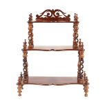 A Victorian walnut three tier graduated whatnot, of small proportions, the shaped shelves raised