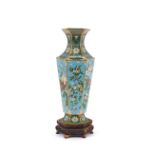 A Chinese cloisonne baluster vase, decorated with birds, insects and foliage on carved hardwood