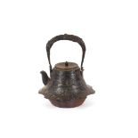 An Antique Japanese iron kettle, with raised decoration and swing handle, 16cm high overall