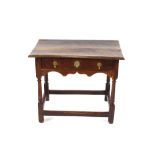 An 18th Century oak side table, fitted with a single drawer above shaped frieze, raised on rounded