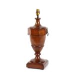 A mahogany baluster vase shaped table lamp, flanked by lion mask ring handles, on square plinth,