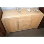 A light oak effect sideboard fitted three drawers