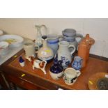 A collection of stoneware bottles and jugs, a cow