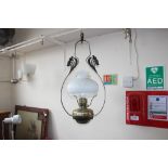A brass and wrought iron hanging oil lamp