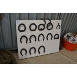 Display board with various horse shoes.
