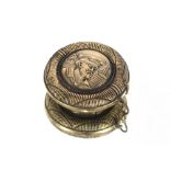 A circular brass snuff box with sailor decoration