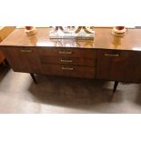 A 1960's faux mahogany sideboard, fitted three cen