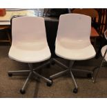 A pair of plastic and metal revolving chairs