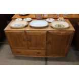 A light Ercol sideboard, fitted cupboards and sing