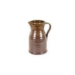 A large brown glazed Studio pottery jug, impress m