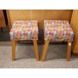 A pair of light oak stools, upholstered in bold coloured sw