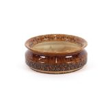 An Iden Rye pottery bowl, having brown glazed dimp