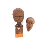 A carved ethnic figure with leather and shell deco