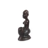 A carved ethnic figure of a seated African naked woman