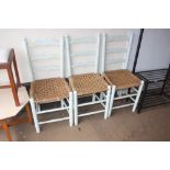 A set of three ladder back painted dining chairs