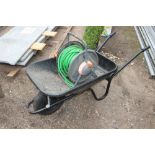 A metal wheel barrow and a hose and reel