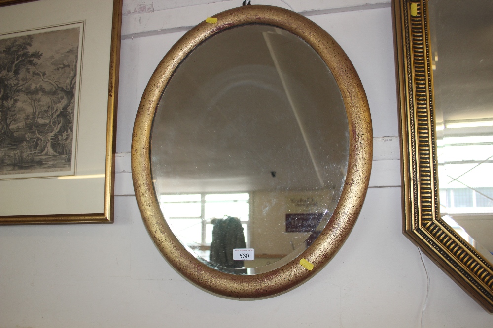 A bevel edged oval framed wall mirror