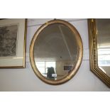 A bevel edged oval framed wall mirror