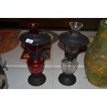 One ruby and one clear glass oil lamp