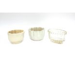 Two white china jelly moulds and a glass similar