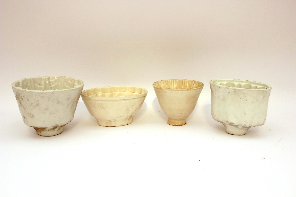 Four various white china jelly moulds