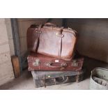 A vintage leather holdall and two suitcases