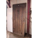 An old oak door with iron hinges, knocker and latc