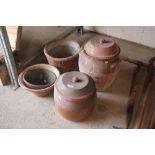 Three various earthenware crocks, a colander and a