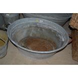An oval galvanised tin bath