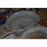 An oval galvanised twin handled bath