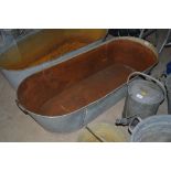 A galvanised twin handled bath