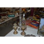 Two brass table oil lamps and a chrome plated simi
