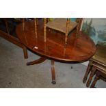 A reproduction yew wood oval topped coffee table