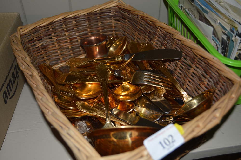 A wicker basket of gold plated cutlery